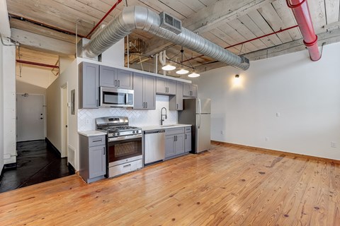 a kitchen with gray cabinets and a wood floor
